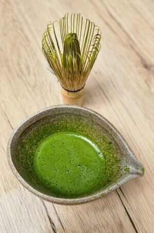 Préparation de thé matcha dans un bol en céramique
