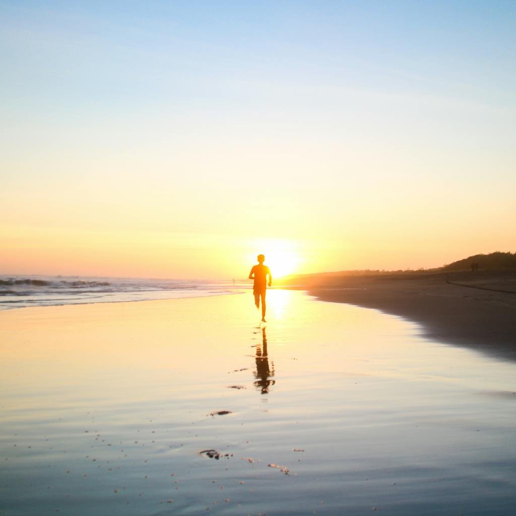 13 vertus du thé vert matcha 3 A lone silhouette of a person running along a serene beach at sunset, reflecting in the wet sand.